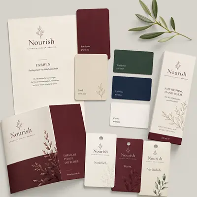 Farbmuster und Materialien im Nourish-Design Farbmusterkarten, Broschüre und Verpackungen in Bordeaux, Grün und Creme