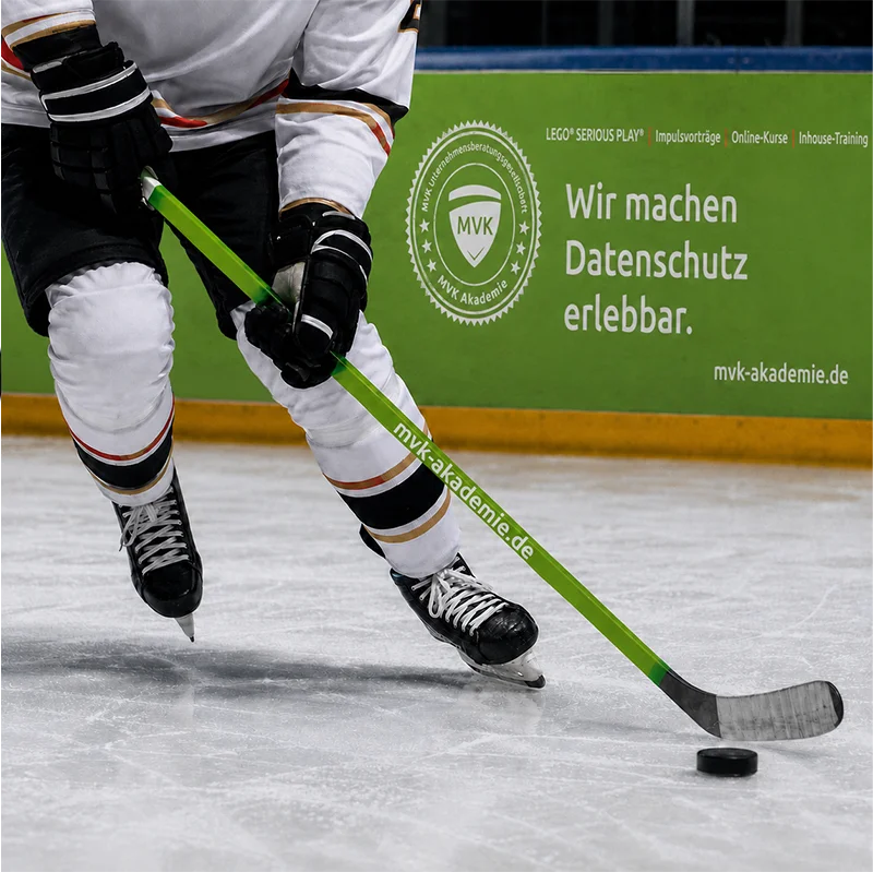 Sonderwerbung für die MVK Akademie Bedruckter Eishockeyschläger und Bandenwerbung der MVK Akademie